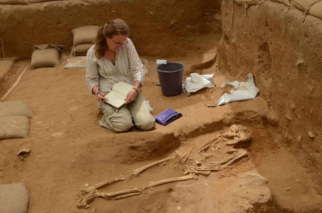 a woman examining a Philistine burial site